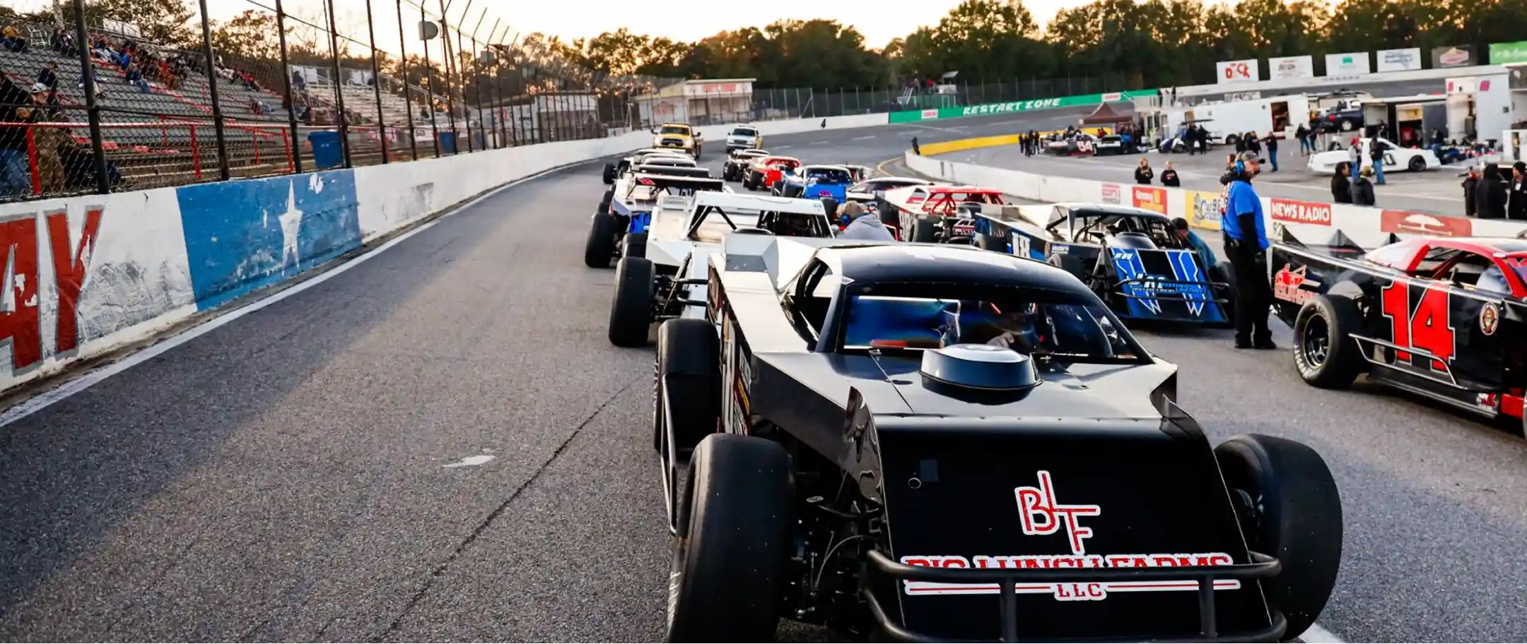 Race cars lined up on the track at sunset, contact page hero