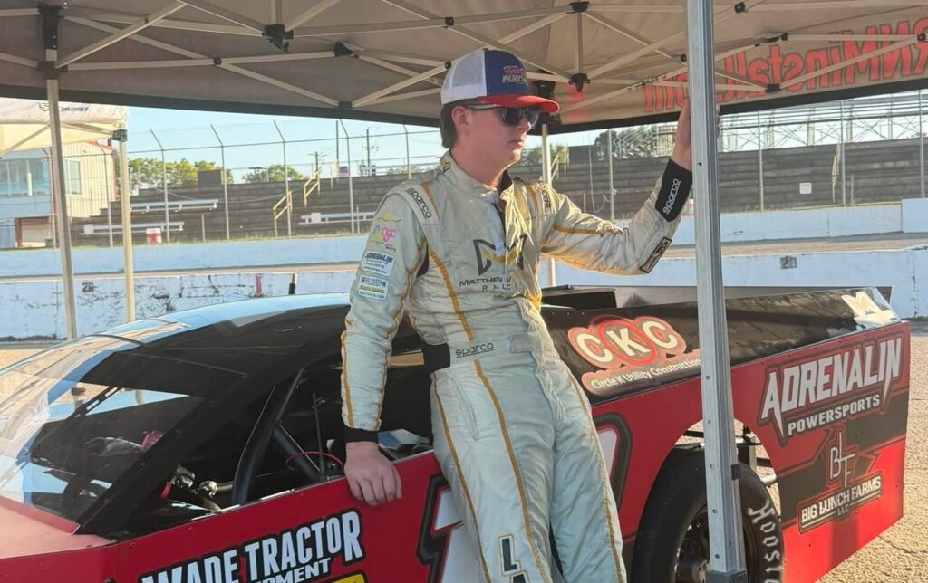Matthew LaPrade in his race suit beside the #18 Modified at Montgomery Motor Speedway